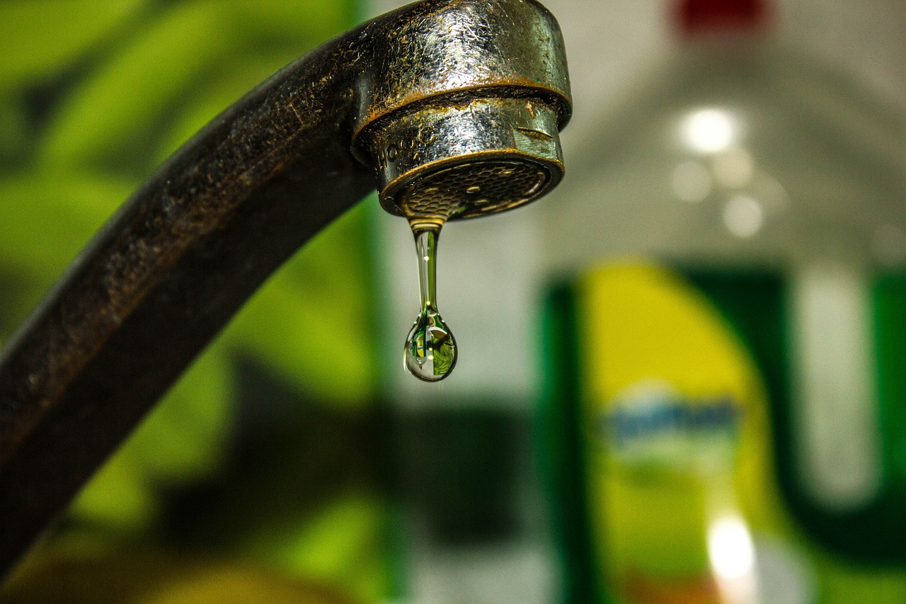 A kitchen tap dripping water with a blurry background